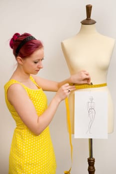 The young seamstress takes measurements of a group of tailors
