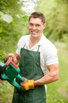 Young gardener with a hedge trimmer