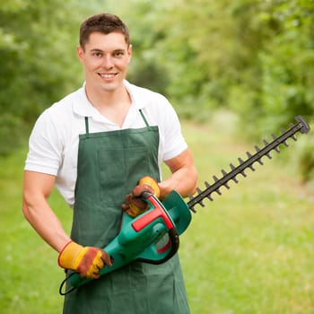 Young gardener with a hedge trimmer