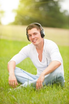 Young man listening to music in a meadow