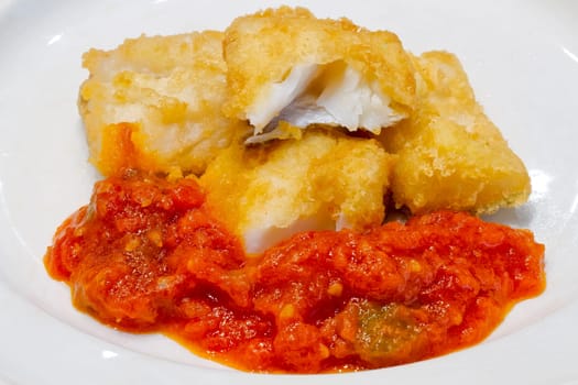 Fried salted codfish ready for a meal, Biscayan cod in, with tomato pisto