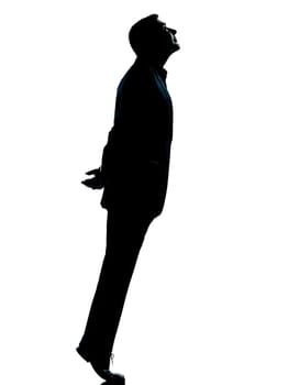 one caucasian business man silhouette standing tiptoe looking up Full length in studio isolated on white background