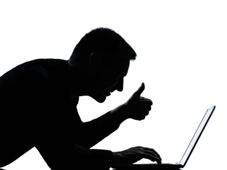 one caucasian business man computing computer laptop thumb up portrait silhouette in studio isolated on white background
