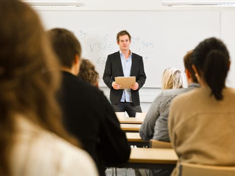 Schoolteacher in front of pupils in the classroom