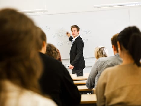Schoolteacher in front of pupils in the classroom