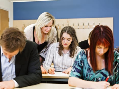 Large group of young adults studying in a classroom