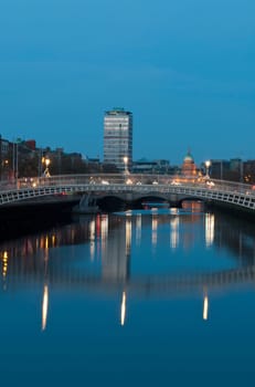 stunning nightscene with Ha&#039 penny bridge and Liffey river, the Custom House landmark at the background (picture taken after sunset)