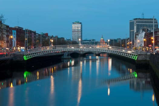 stunning nightscene with Ha&#039 penny bridge and Liffey river, the Custom House landmark at the background (picture taken after sunset)
