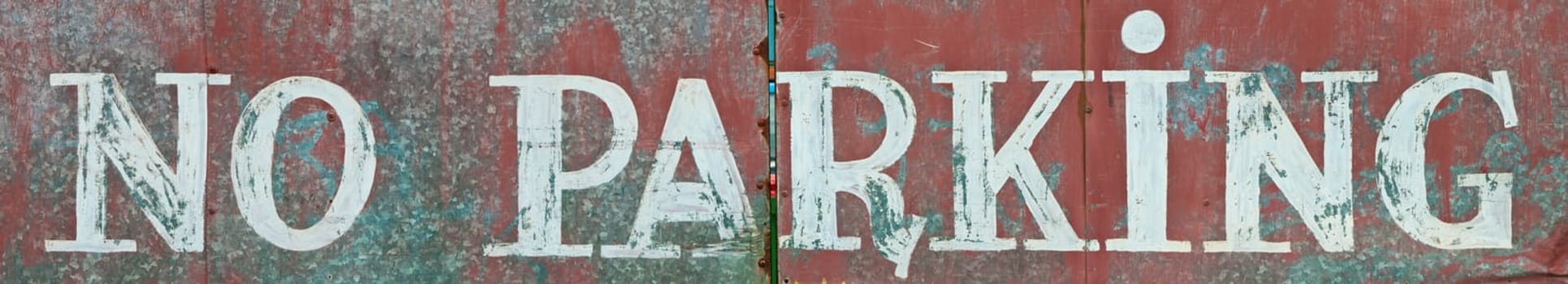 no parking written on a rusty metallic surface (panoramic picture)