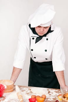 pensive chef is thinking on the gray background