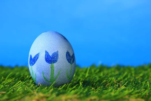 Easter decoration made of single,colorfully painted,Easter egg in green artificial grass