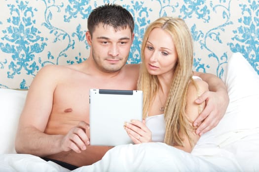 Couple with tablet computer in the bed
