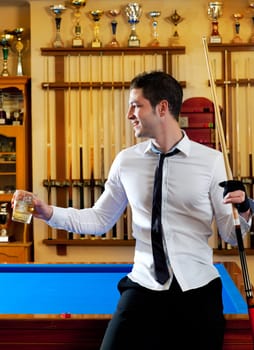 Billiard handsome young winner man with shirt tie and cue at trophy club