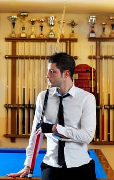 Billiard handsome young winner man with shirt tie and cue at trophy club