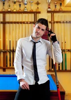 Billiard handsome young winner man with shirt tie and cue at trophy club