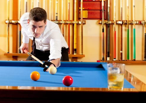 Billiard winner handsome man playing with cue and balls at club