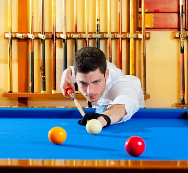 Billiard winner handsome man playing with cue and balls at club