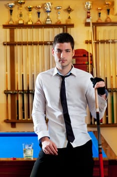 Billiard handsome young winner man with shirt tie and cue at trophy club