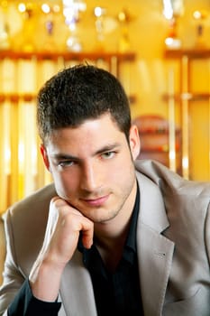 handsome man with suit sitting posing in billiard pool in club