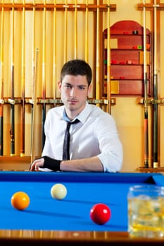 Billiard expertise man posing on blue with alcohol on the rocks glass