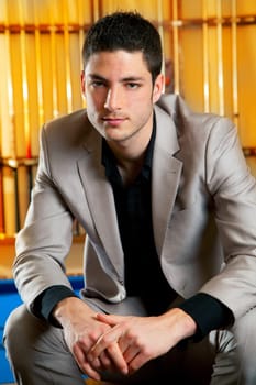 handsome man with suit sitting posing in billiard pool in club