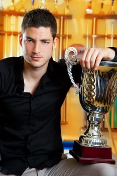 Happy proud winner man with big trophy silver cup in billiard club