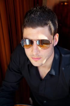 Handsome young man portrait with sunglasses and black shirt