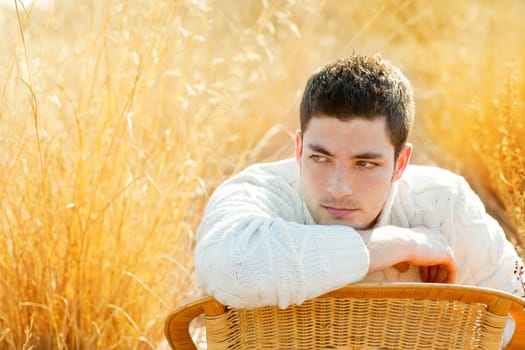 Autumn winter man portrait  in golden grass field with turtleneck sweater