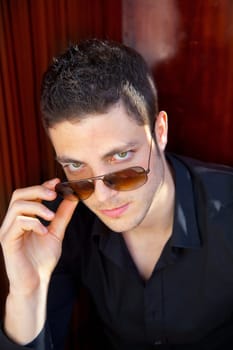 Handsome young man portrait with sunglasses and black shirt