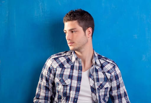 handsome young man with plaid shirt on blue background