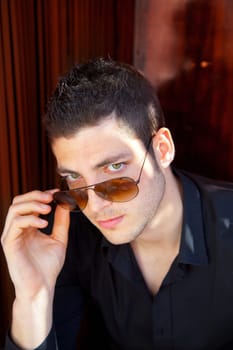 Handsome young man portrait with sunglasses and black shirt