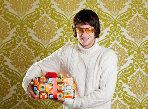 retro hip young man glasses holding  psychedelic gift box on wallpaper