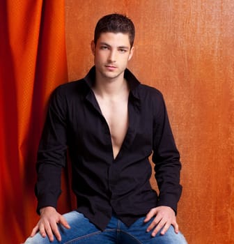 Latin spanish man portrait open black shirt with curtain and orange vintage background