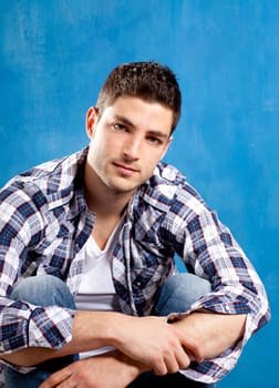 handsome young man with plaid shirt on blue background