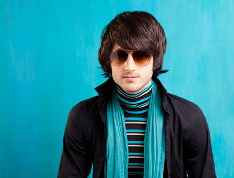 british indie pop rock look retro hip young man with sunglasses on blue