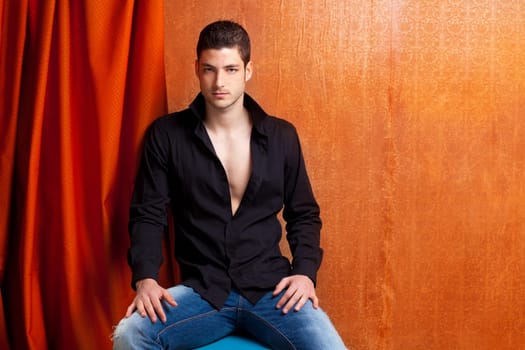 Latin spanish man portrait open black shirt with curtain and orange vintage background