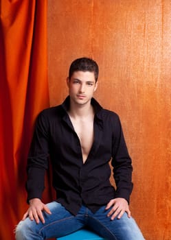 Latin spanish man portrait open black shirt with curtain and orange vintage background