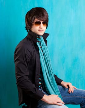 british indie pop rock look retro hip young man with sunglasses on blue