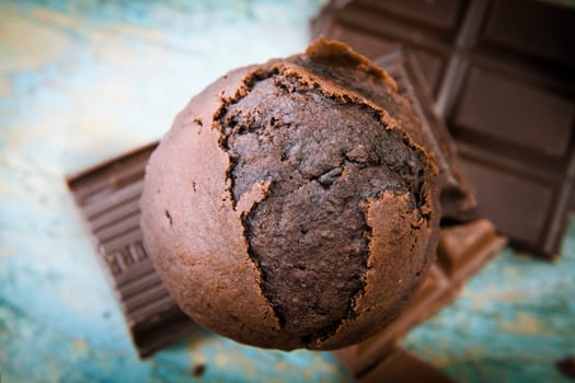 Overhead view of a freshly baked scrumptious chocolate muffin with pieces of chocolate