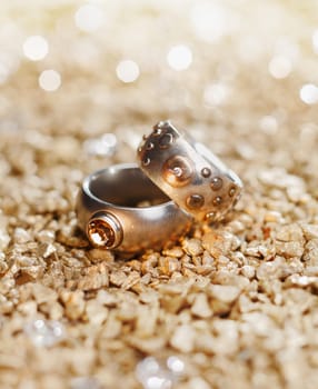 Two Rings with jewels on a golden background maybe for a wedding card