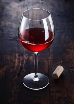 Dark red Merlot or Burgundy Wine with a cork on a wooden background