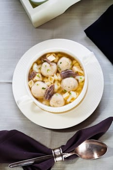 Overhead view of a delicious bowl of gourmet mushroom soup with whole mushrooms served at a table place setting