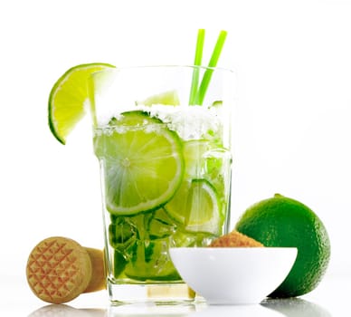 Caipirinha isolated on white background, with a mortar and brown sugar and sliced limes