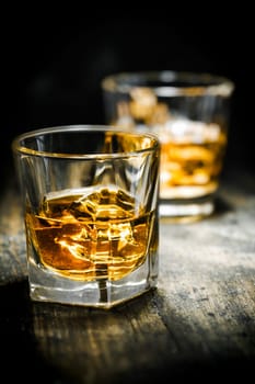 Whisky or Whiskey, vintage style, on a wooden plate