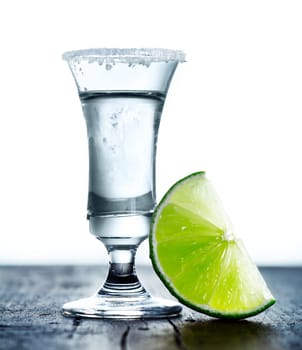 Tall glass with Margarita drink, salted rim and lime.
