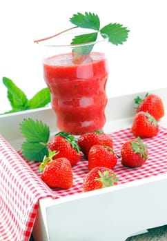 Fresh strawberries and strawberry juice on red checkered tablecloth