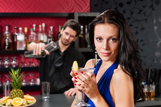 Attractive young woman at cocktail bar enjoy drink from bartender