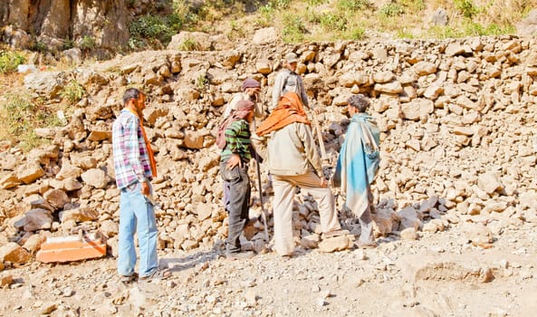Shiva Kodi, Kashmir, India - December 18, 2011: Editorial, wall building gang along the public foot path to Shiv Kodi hindu temple having a break from breaking rocks