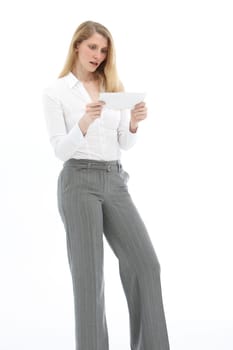 Young woman looking at an envelope in horror and standing in front of a white background