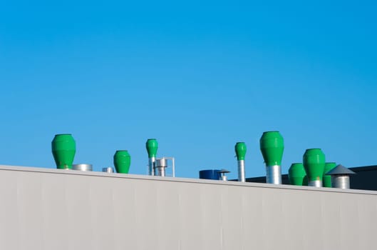 several small chimneys on the roof of an industrial building